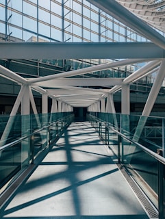 a long walkway with metal railings leading to a building