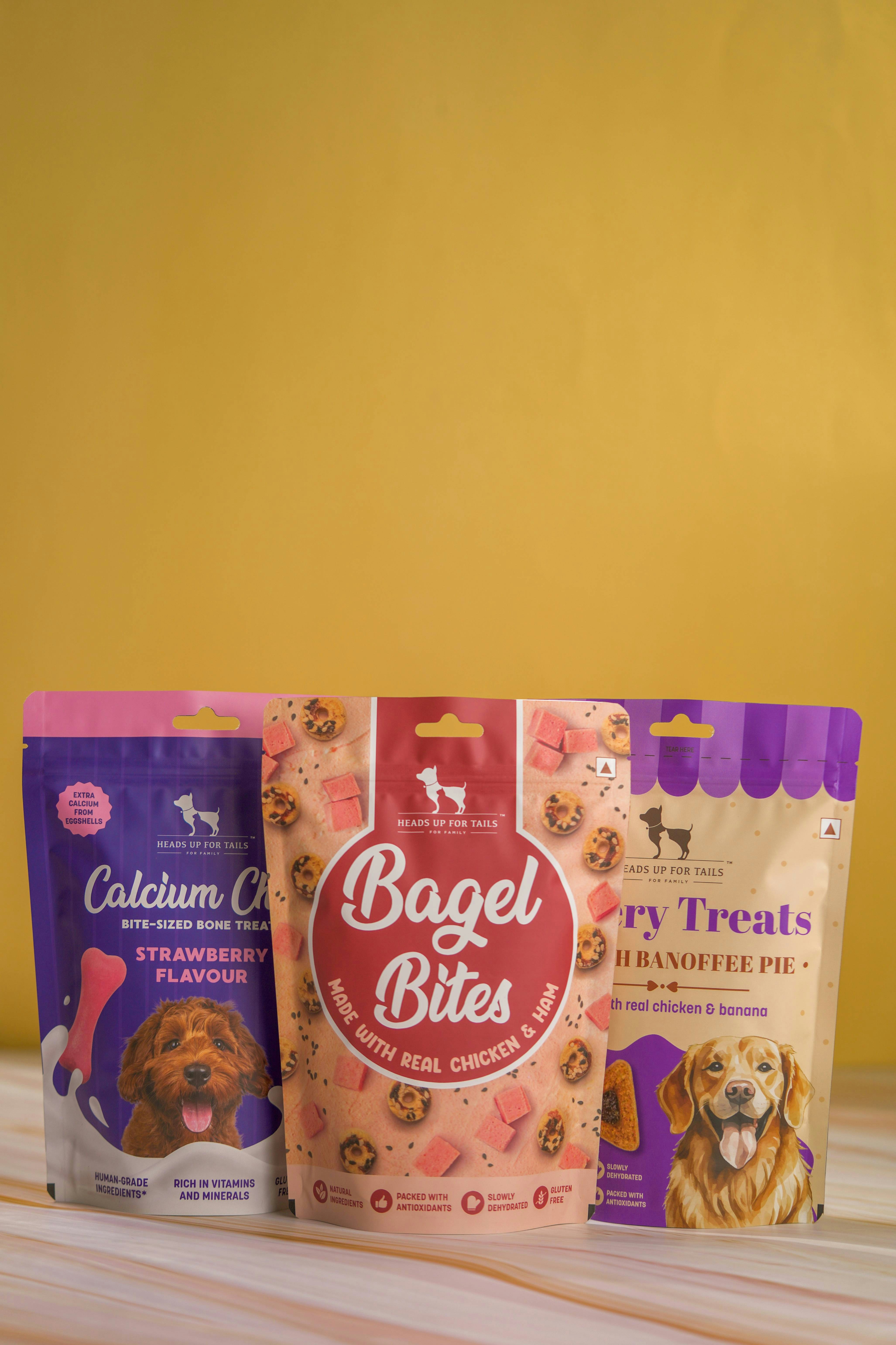 three bags of dog treats sitting on a table