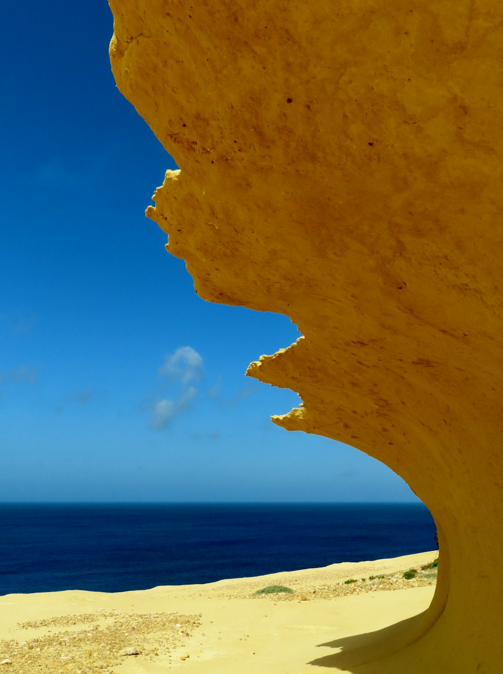 a view of the ocean through a crack in a rock