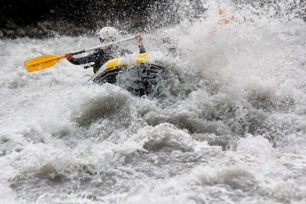 a man riding a raft on top of a wave