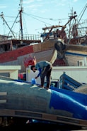 a man standing on top of a blue airplane