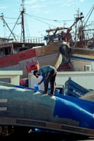 a man standing on top of a blue airplane
