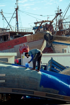 a man standing on top of a blue airplane