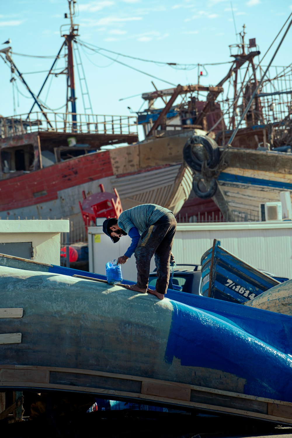 a man standing on top of a blue airplane