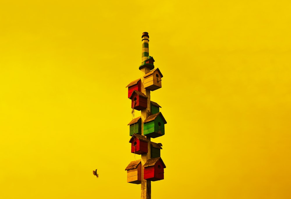 a colorful birdhouse on top of a tall pole