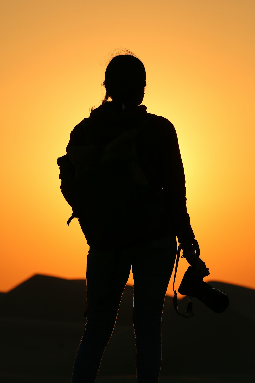 a silhouette of a person holding a skateboard
