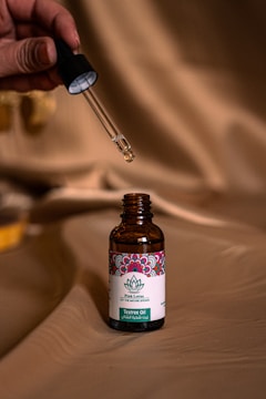 a person holding a small bottle of medicine