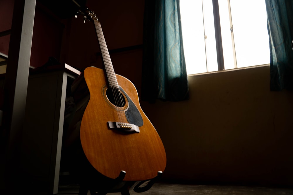 uma guitarra sentada em frente a uma janela
