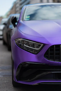 a purple sports car parked on the side of the road