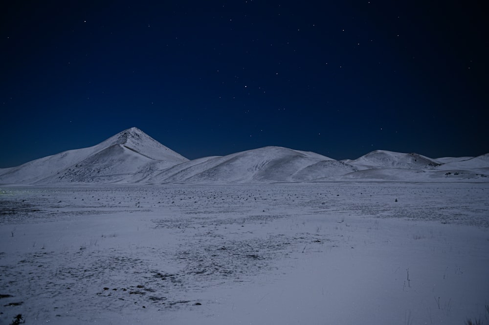 un campo cubierto de nieve con montañas al fondo