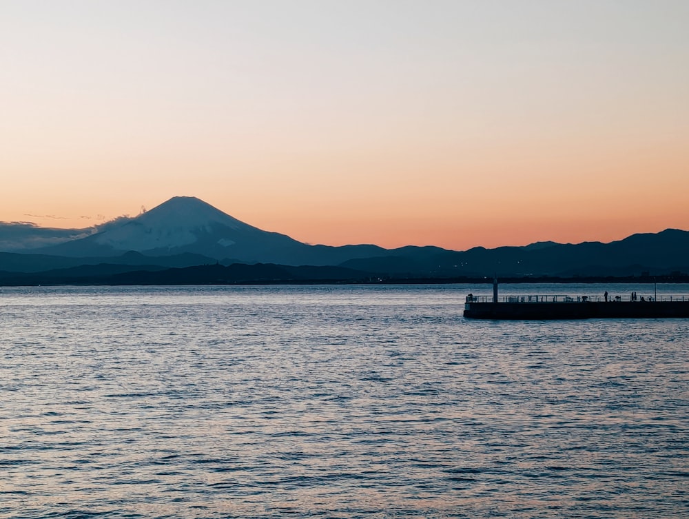 a large body of water with a mountain in the background