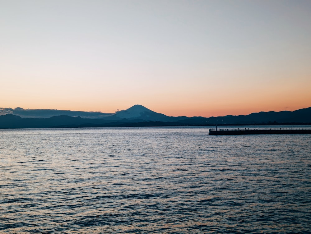 a body of water with mountains in the background