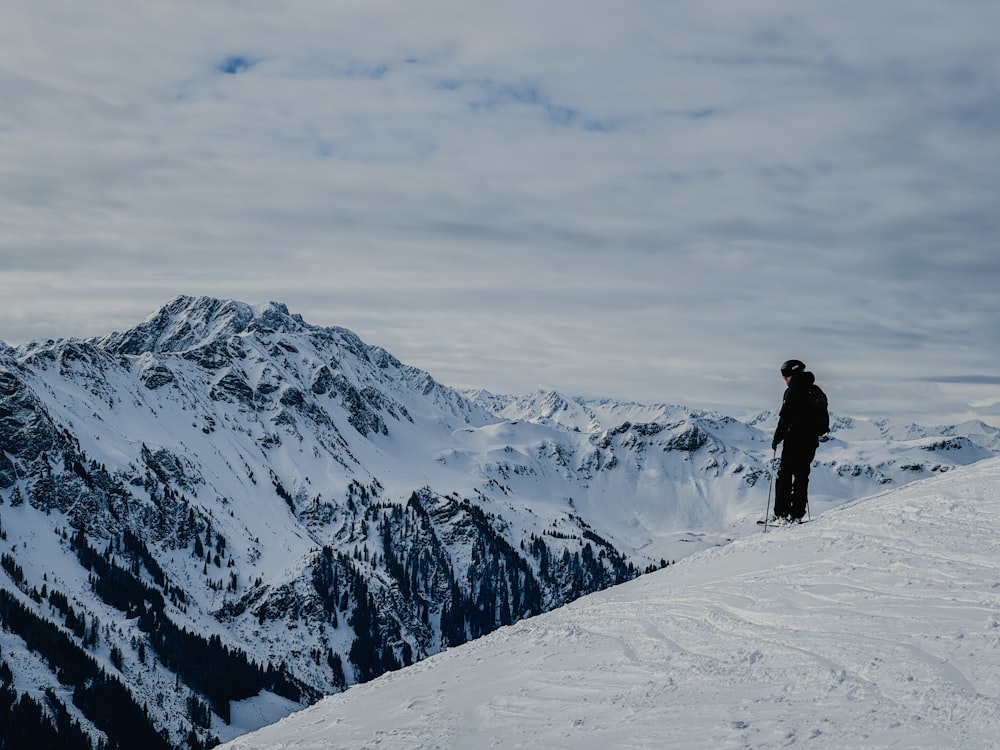 a person standing on top of a snow covered mountain