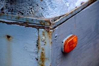 a rusted metal box with a red light on it