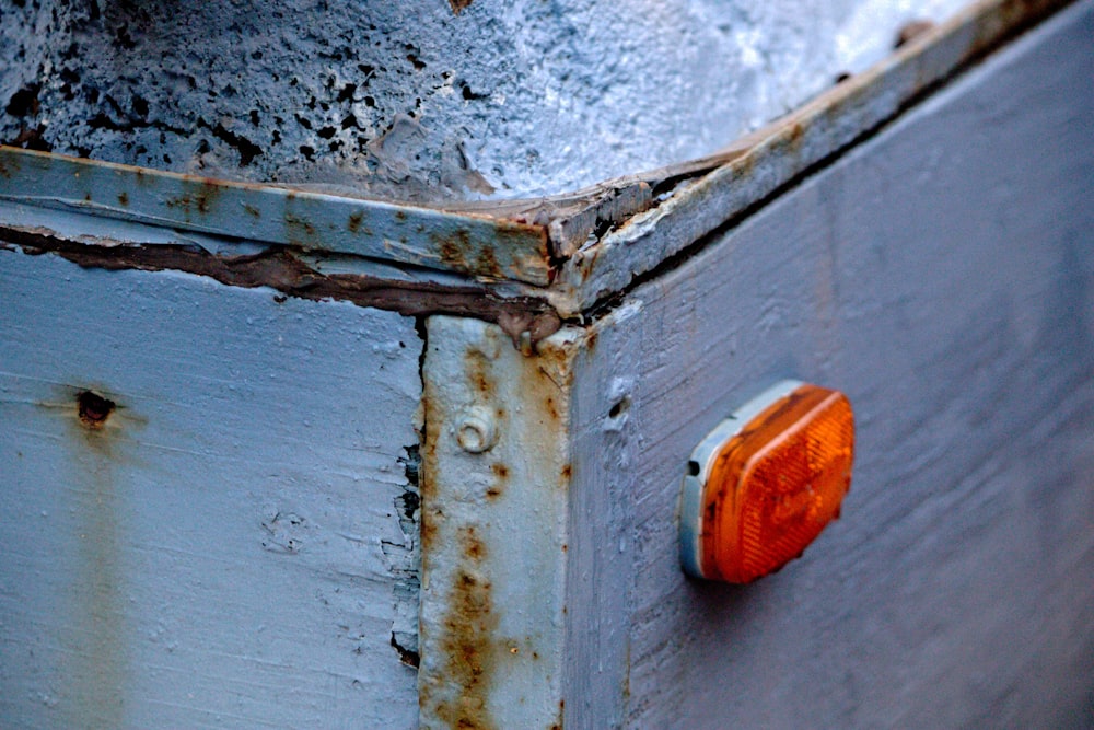 a rusted metal box with a red light on it