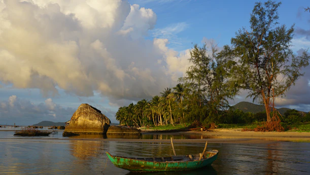 a green boat sitting on top of a body of water
