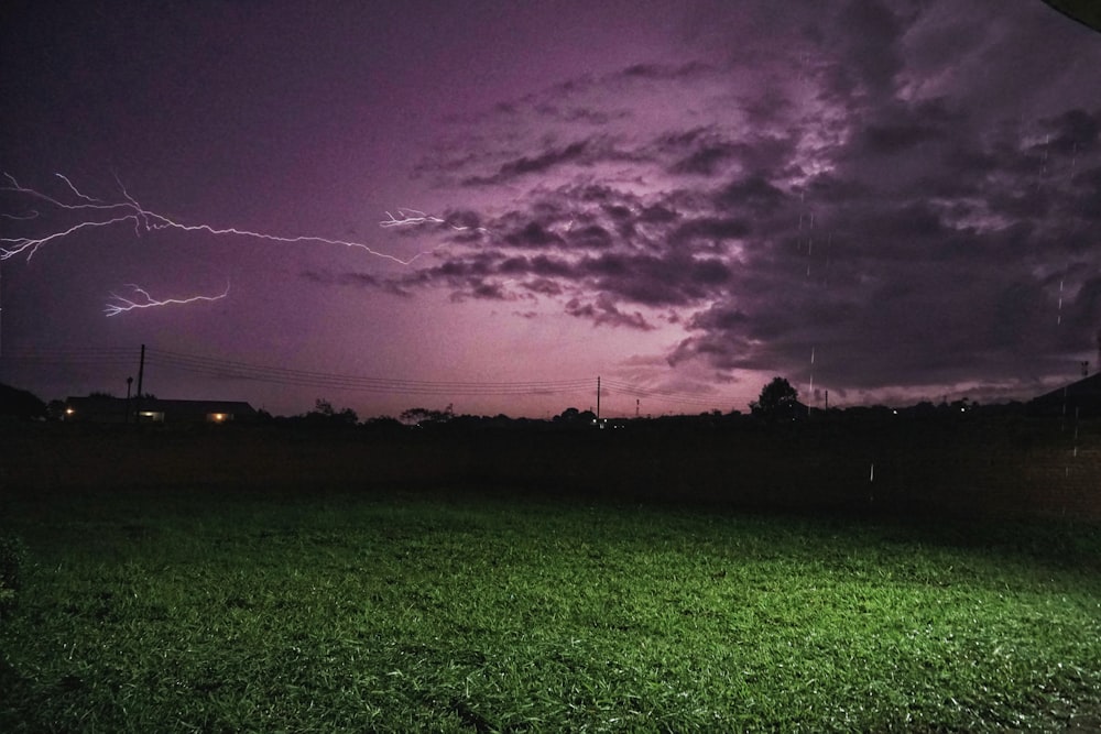a purple and black sky with lightning in the distance
