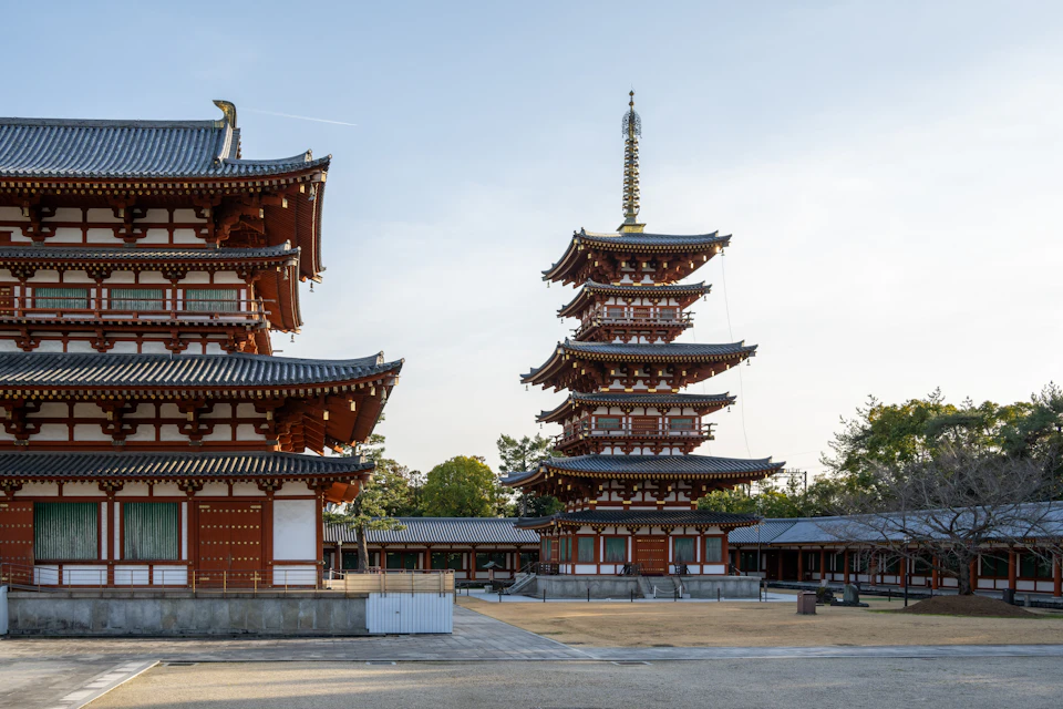 The image depicts a serene scene at a traditional Japanese temple complex, featuring two distinct pagodas with red roofs and white walls. The first pagoda is situated on the left side of the frame, while the second one dominates the right side. Both structures are adorned with intricate carvings and statues, showcasing the rich cultural heritage of Japan. In front of these majestic buildings, there's a spacious courtyard that appears to be a common area for visitors or locals to gather and enjoy the peaceful surroundings.

The sky above is a clear blue, providing a beautiful backdrop to the architectural marvels below. The image also contains some text, which reads "sa_20038", but its relevance to the scene remains unclear without additional context.
