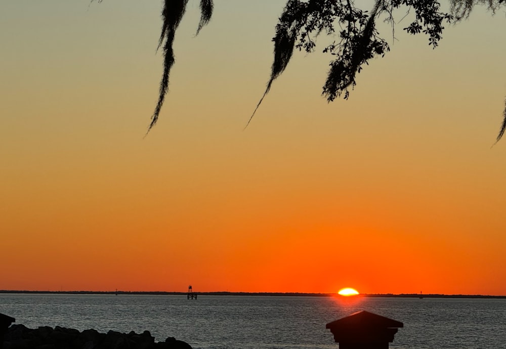 the sun is setting over a body of water