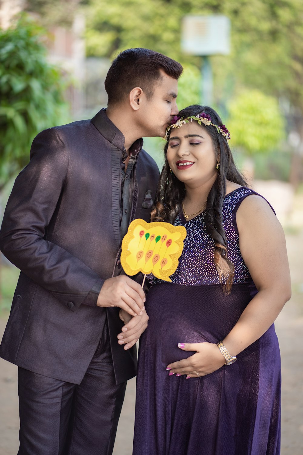 a pregnant woman and man pose for a picture