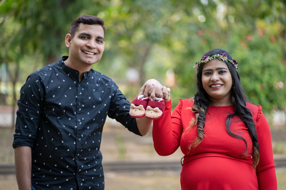 a pregnant woman holding a piece of food next to a man