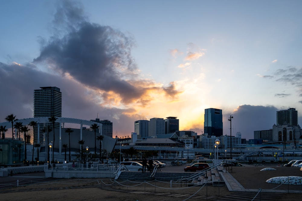 the sun is setting over a city with tall buildings