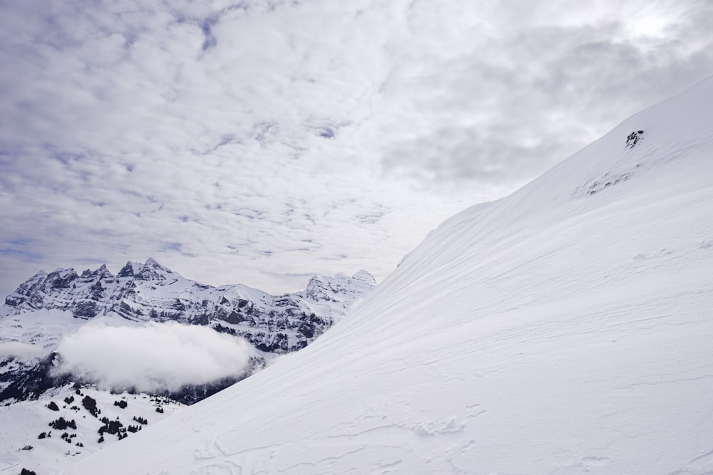 a man riding skis down the side of a snow covered slope