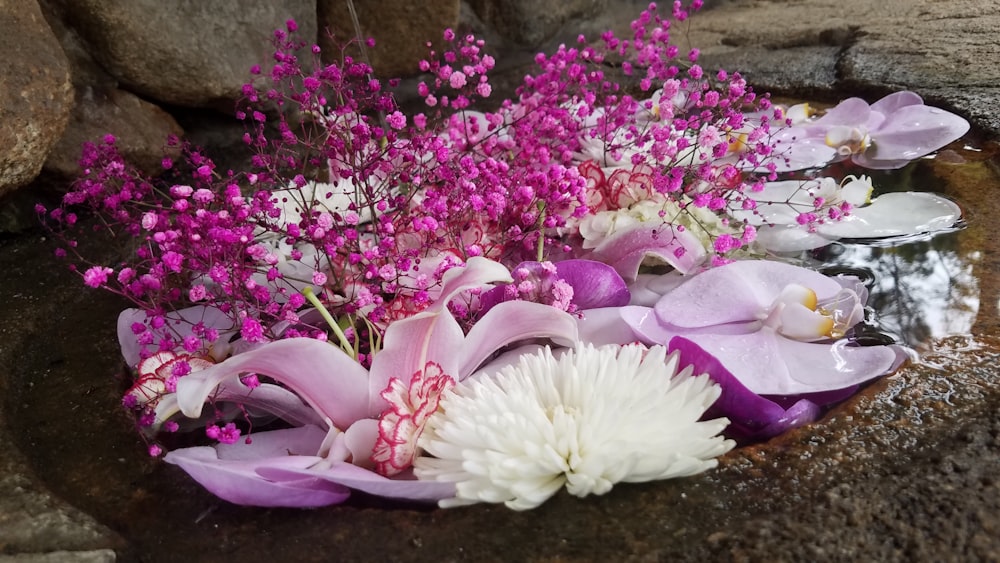 a bouquet of flowers sitting on top of a rock