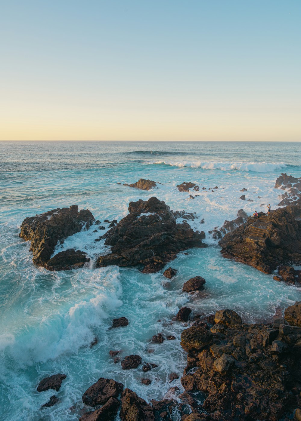 a view of the ocean from a rocky shore