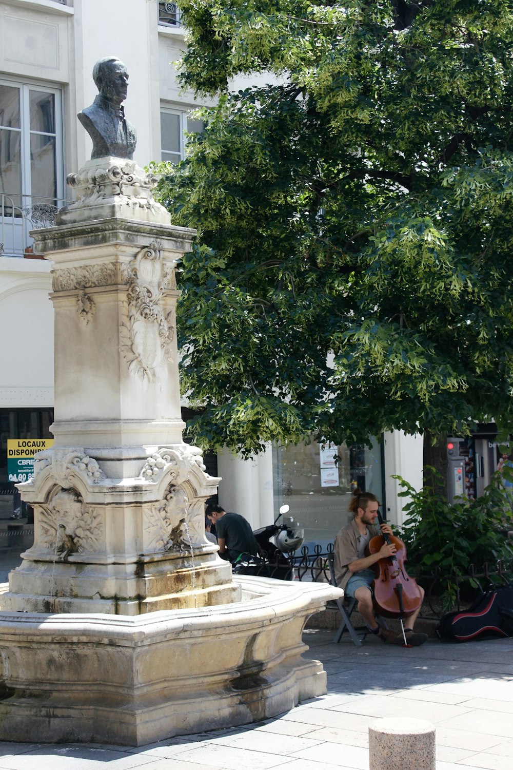 a woman sitting on a bench next to a statue