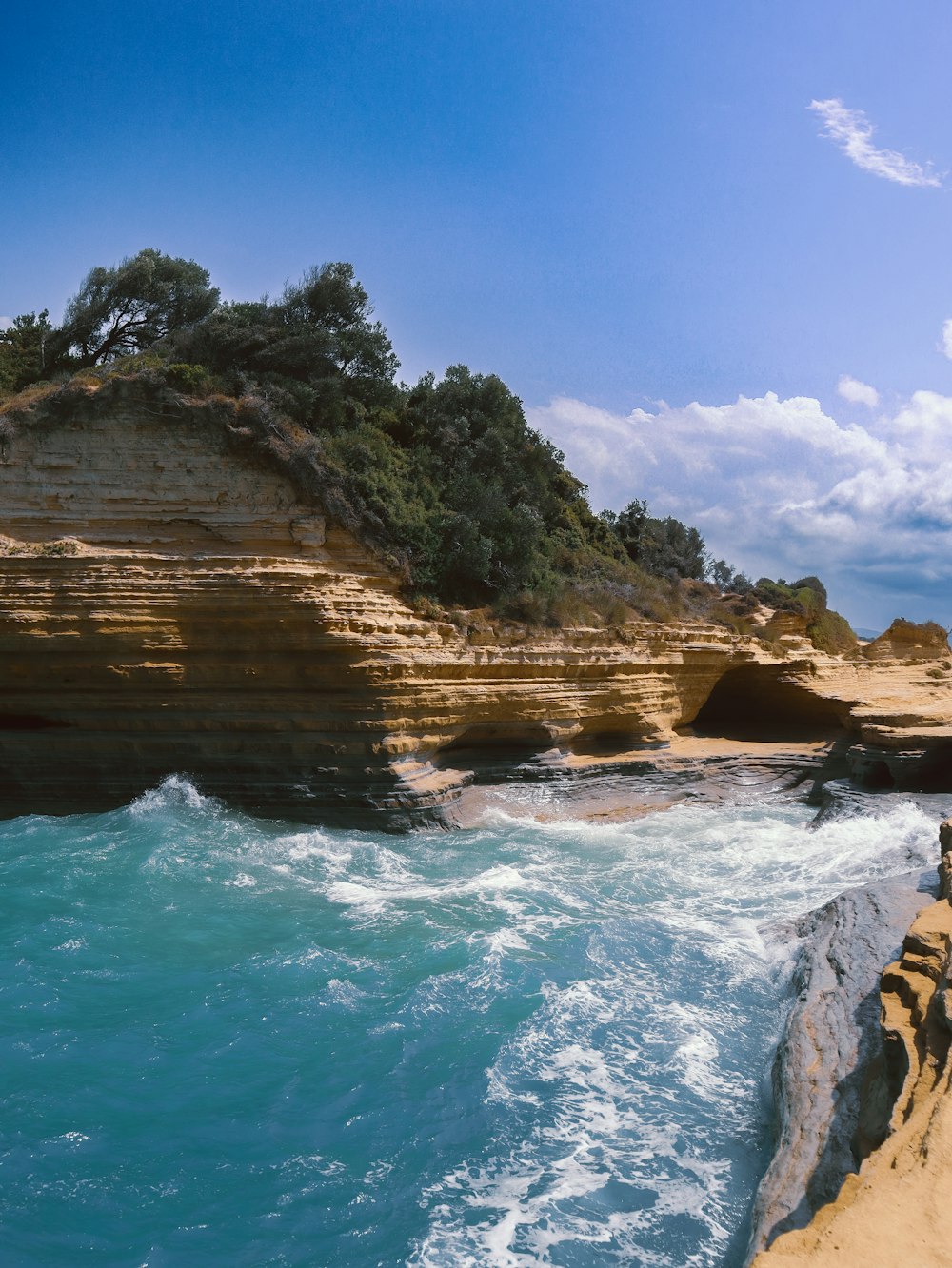 a beach with a cliff and a body of water