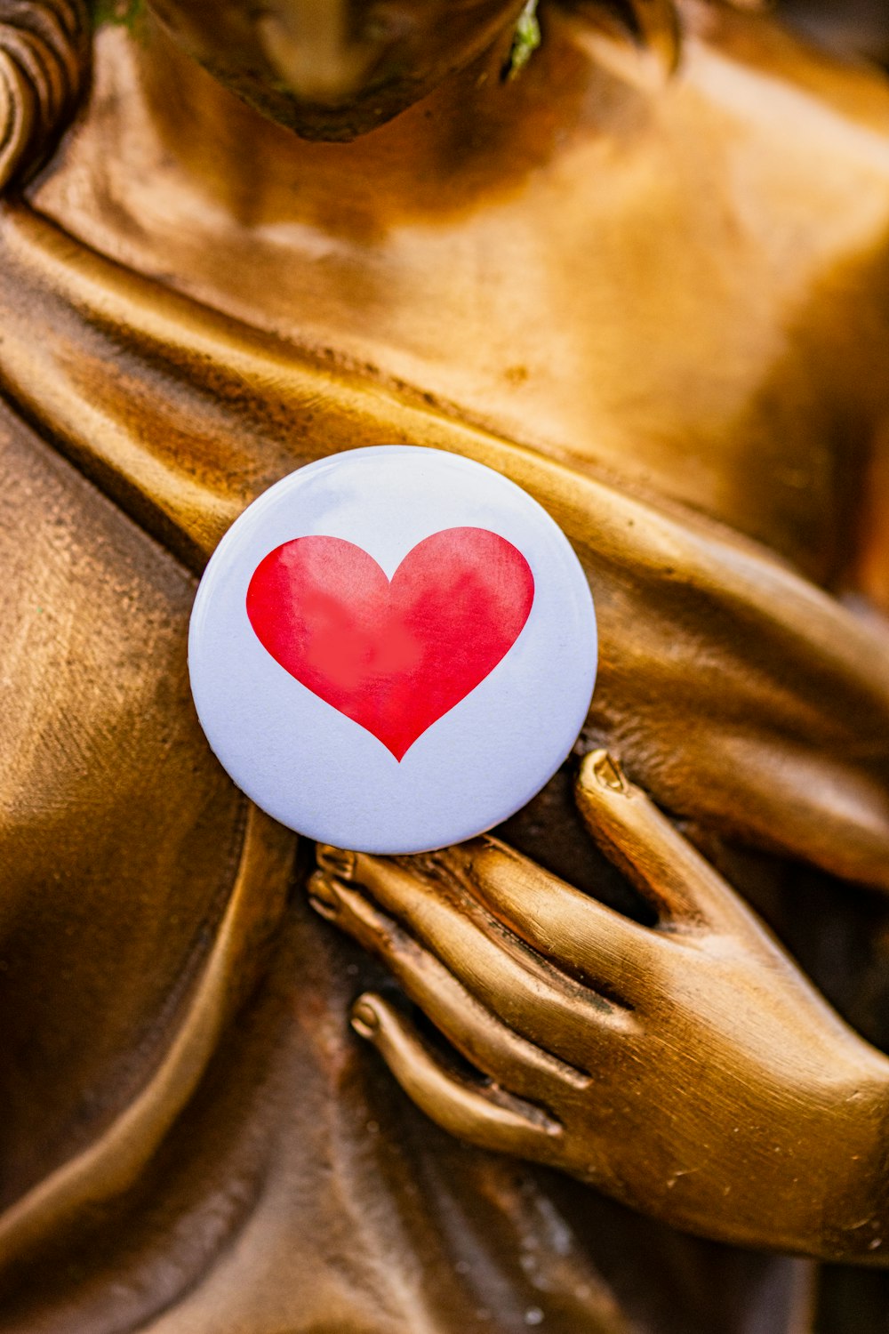 a button with a heart on it on a statue