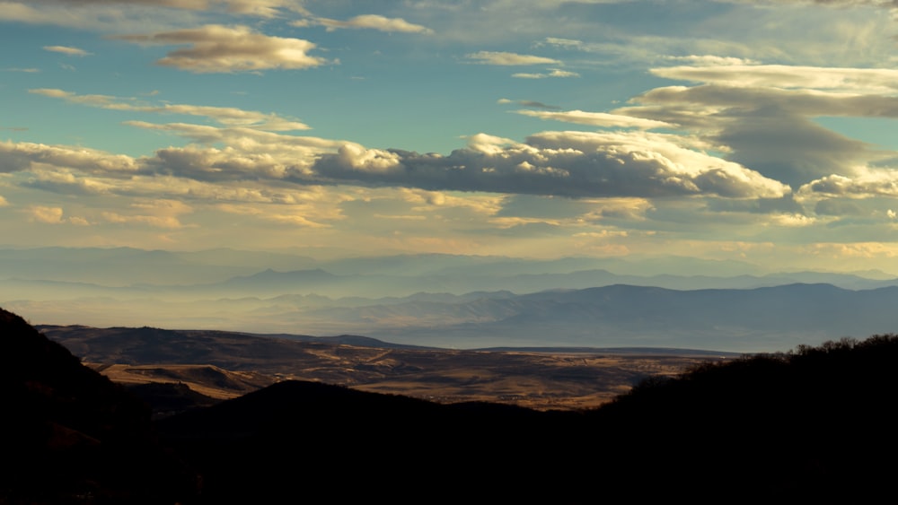 a view of a mountain range with clouds in the sky