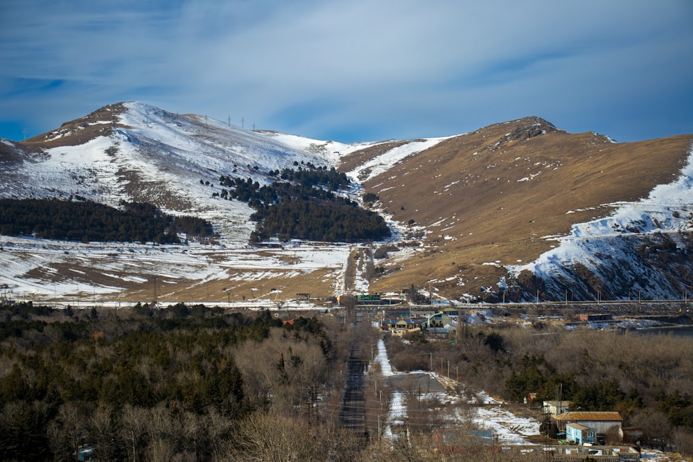 a snowy mountain range with a train on the tracks