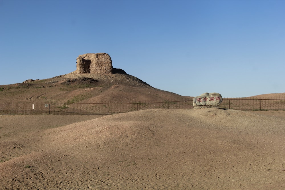 a dirt hill with a rock outcropping in the distance