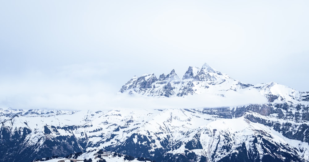 un grupo de personas de pie en la cima de una montaña cubierta de nieve