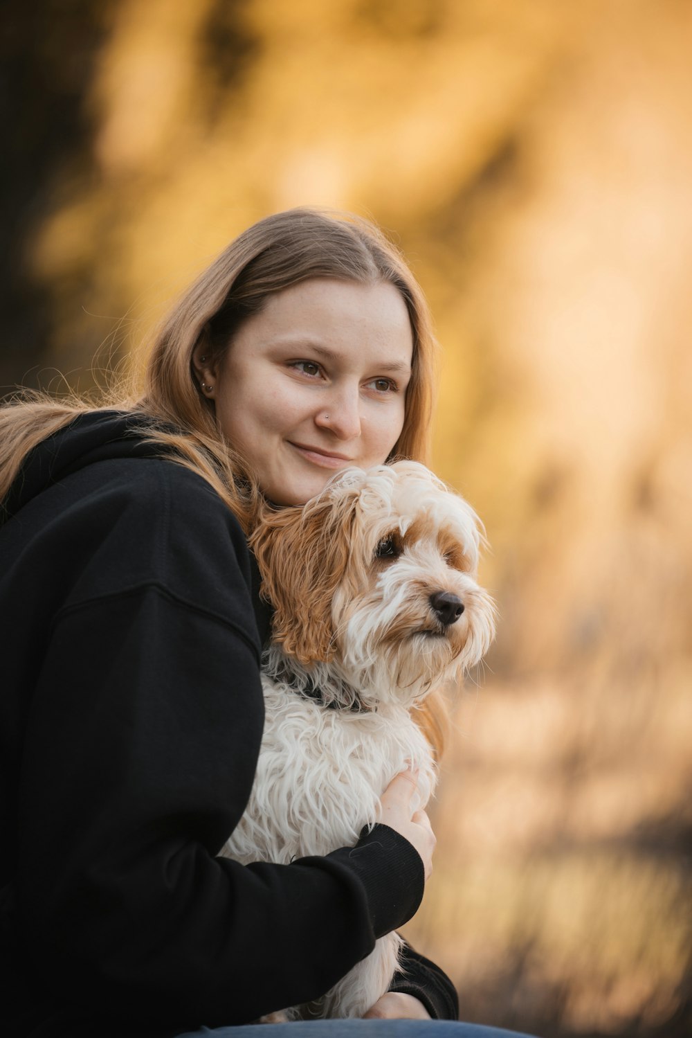 a woman holding a small dog in her arms