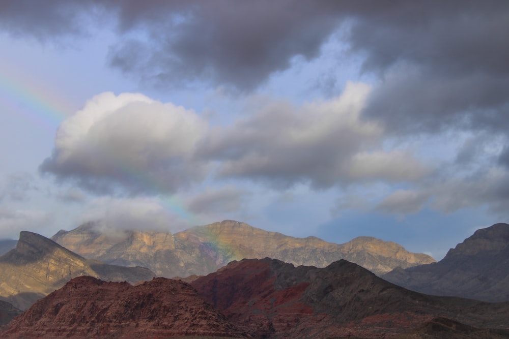 a rainbow in the sky over a mountain range