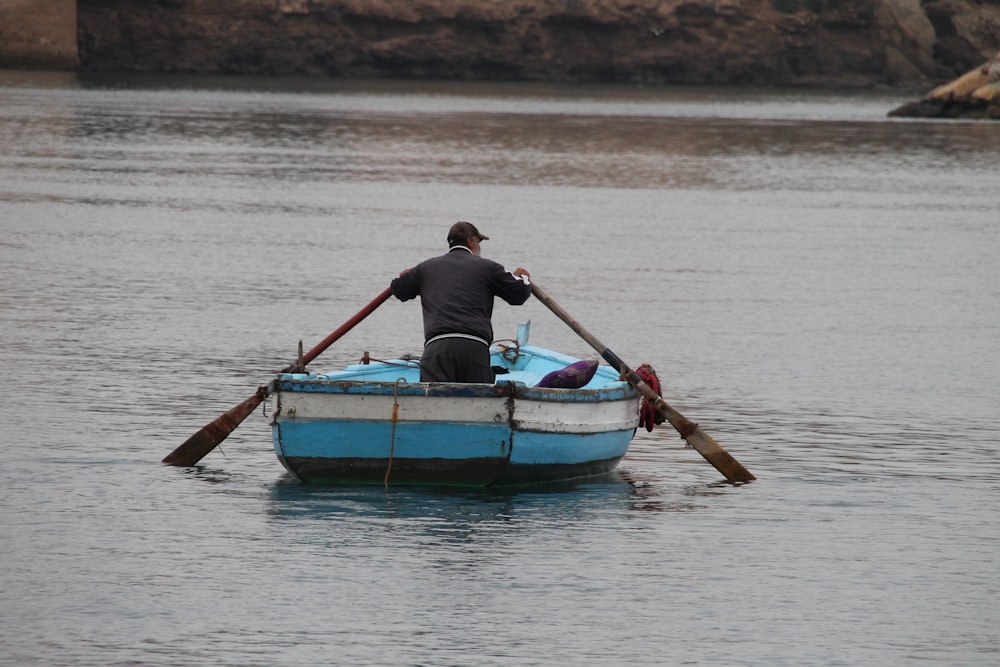 a man in a blue and white row boat