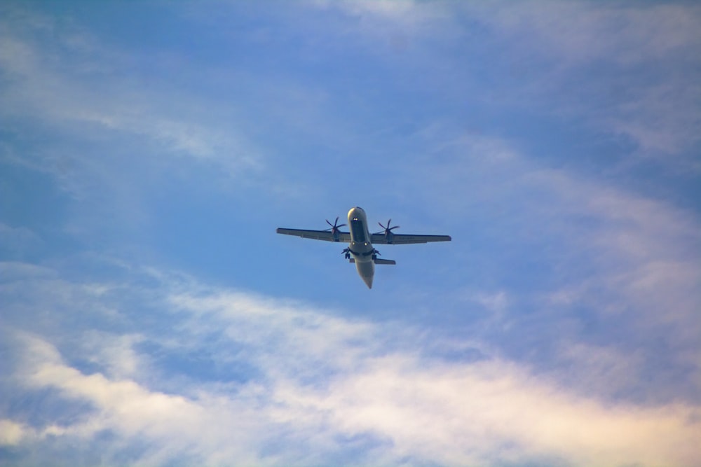 an airplane is flying through the blue sky