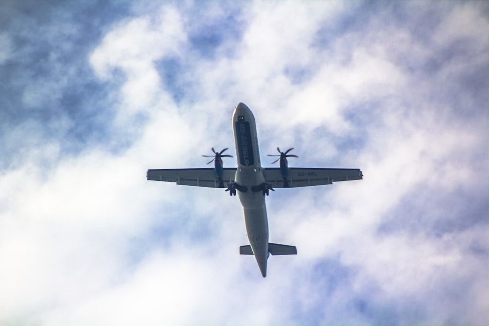 an airplane is flying in the sky on a cloudy day