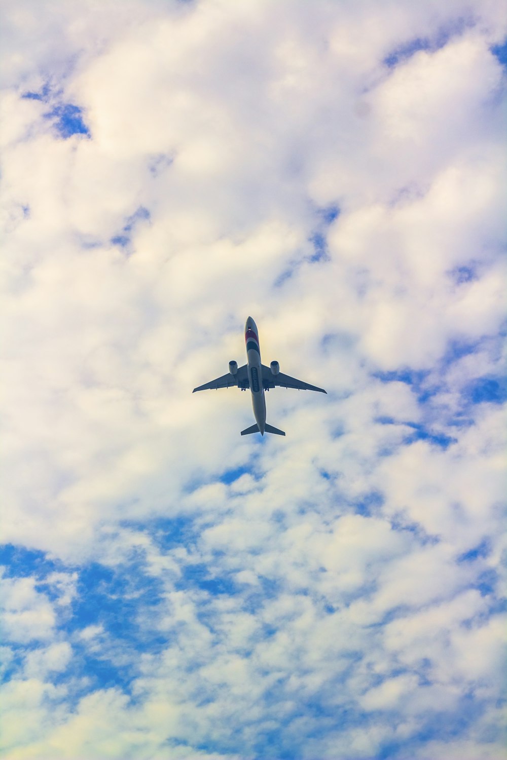 an airplane is flying through a cloudy blue sky