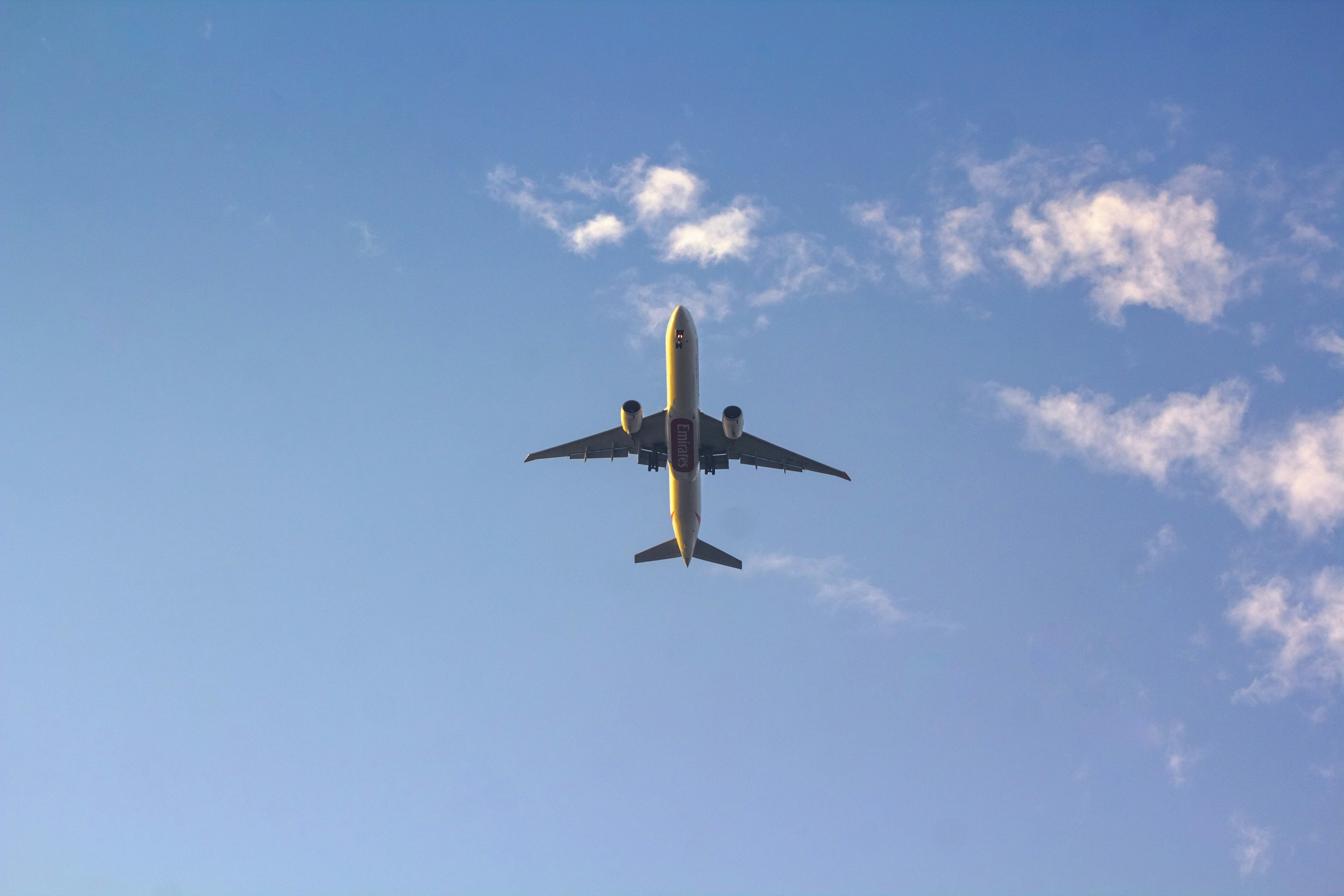 a large jetliner flying through a blue sky, Airplane flying in blue skies! Emirates Boeing 777-300ER