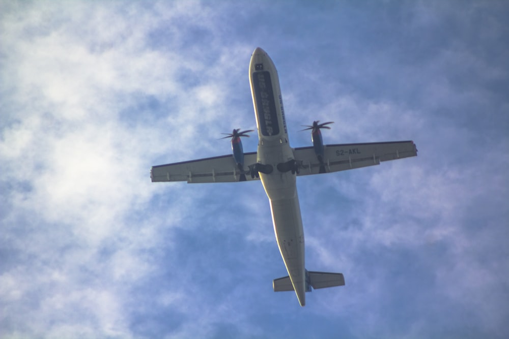 a large jetliner flying through a blue cloudy sky