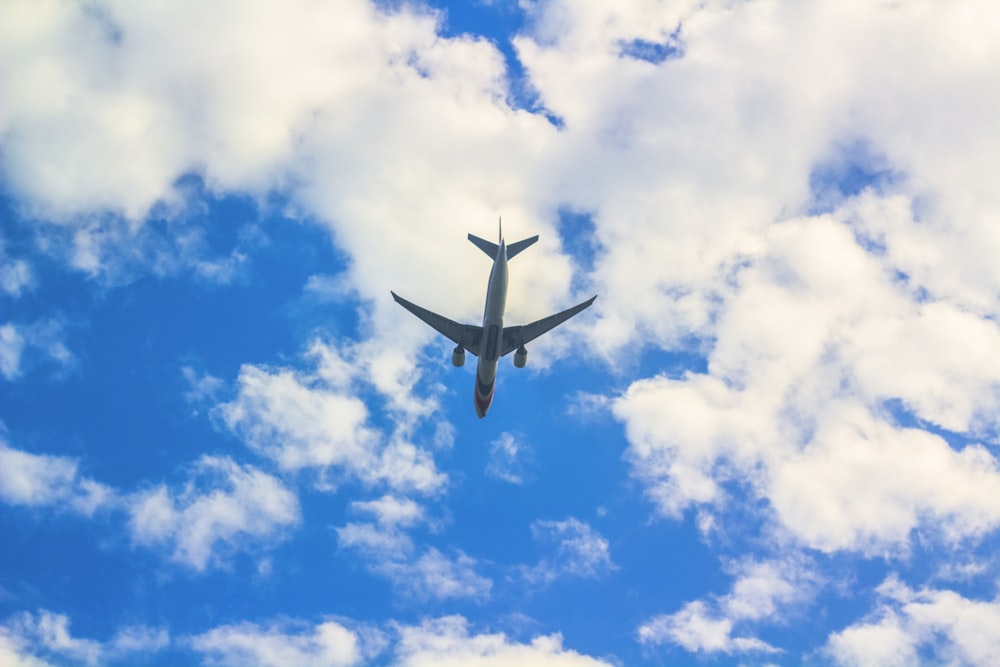 an airplane is flying through the blue sky