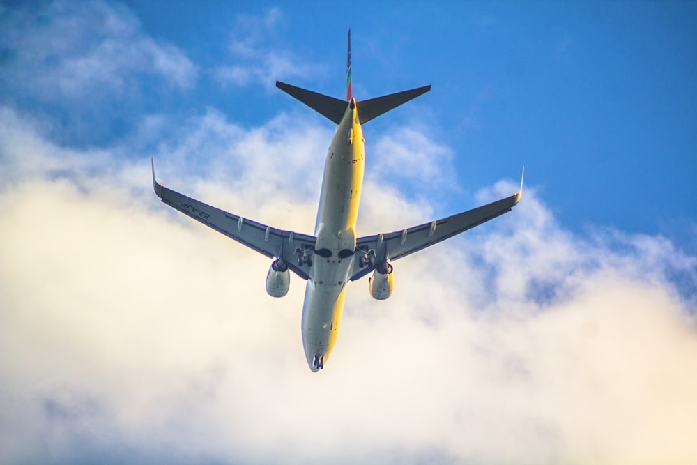 a large jetliner flying through a cloudy blue sky