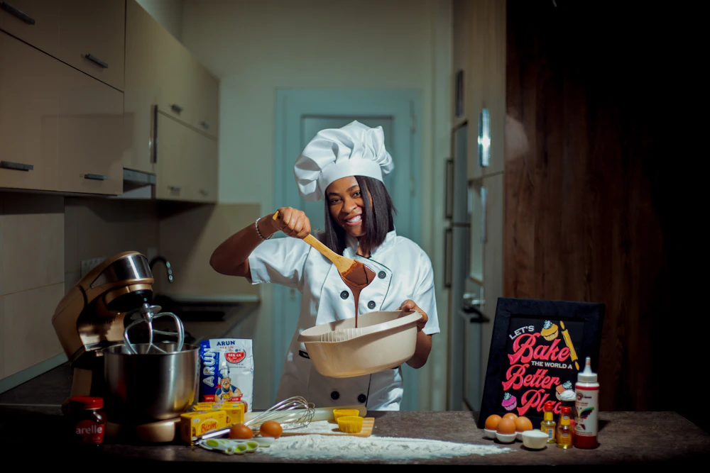 A Black chef holding a wooden spoon