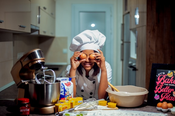 a woman in a chef's hat holding eggs in front of her face