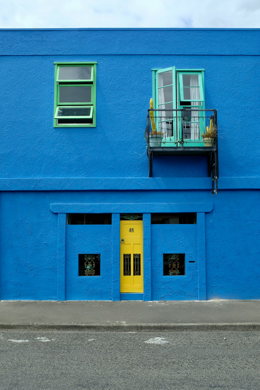 黄色いドアと窓のある青い建物