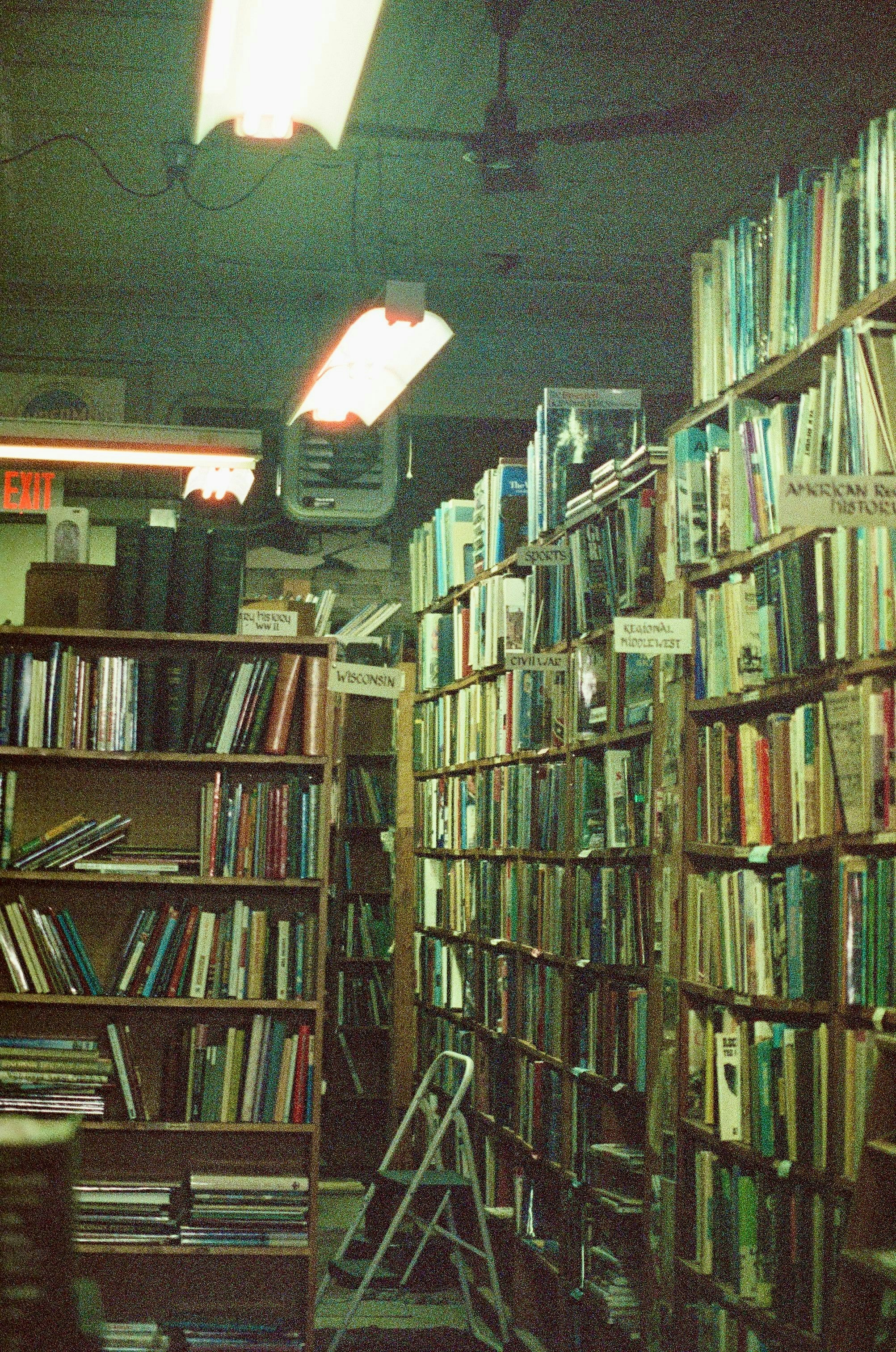 a room filled with lots of books and a ladder